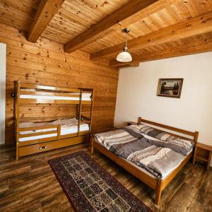 two bunk beds in a room with wooden walls at Adventure Farm in Štore