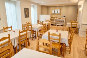 a restaurant with tables and chairs and a kitchen at Hotel Anglada in Vielha +25 photos