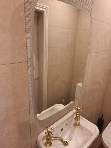 a bathroom with a sink and a mirror at Sunny Hills Cottage in Cornamona
