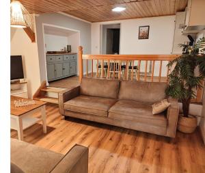 a living room with a couch and a table at Reetmeer Apartments Spa & Reetdach am Salzhaff in Boiensdorf +21 photos