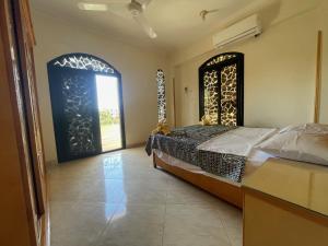 a bedroom with a bed and an open door at Sunflower in Al Aqālitah +12 photos