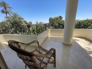 a rattan chair sitting on a balcony at Sunflower in Al Aqālitah