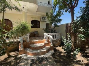 a courtyard with stairs and trees in a house at Sunflower in Al Aqālitah