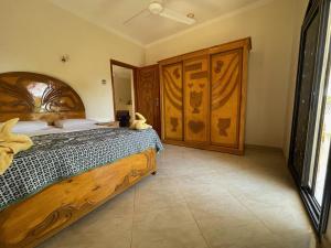 a bedroom with a bed with a teddy bear on it at Sunflower in Al Aqālitah