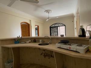 a kitchen counter with a stove and a sink at Sunflower in Al Aqālitah
