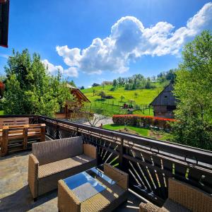 a balcony with chairs and a table and a barn at Adventure Farm in Štore