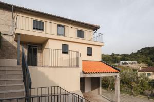 an apartment building with an orange tile roof at Casa do Formão in Amarante
