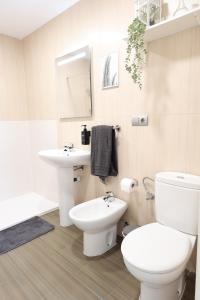 a white bathroom with a toilet and a sink at Puerta de Arcos in Arcos de la Frontera +23 photos