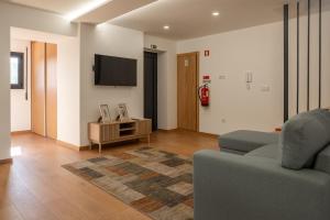 a living room with a couch and a tv at Casa do Formão in Amarante