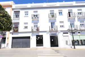 a white building with black doors and windows at Puerta de Arcos in Arcos de la Frontera