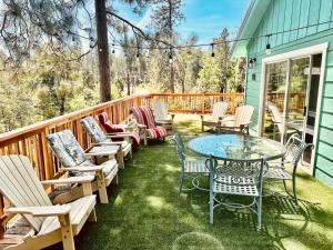 a patio with chairs and a table on a deck at Wishon Cabin - Boat Slip - BBQ, Sleeps 14, Dogs Ok in The Pines