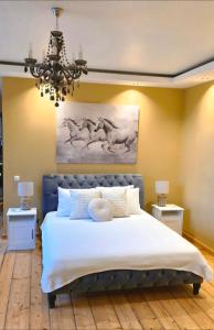 a bedroom with a large bed with a chandelier at Dundagas rezidence in Dundaga