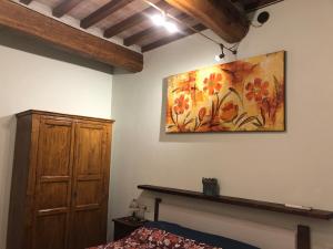 a bedroom with a painting of flowers on the wall at Casa Varna in Gambassi Terme