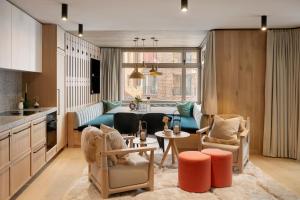 a kitchen and a living room with a couch and a table at Andermatt Alpine Apartments in Andermatt