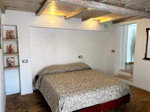 ein Schlafzimmer mit einem Bett in einem weißen Zimmer in der Unterkunft BeB Le Masere in Madonna di Fornelli