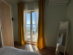 a bedroom with a window with a view of the ocean at Apartments New Charming in Senj