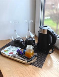 a tray with a coffee maker and glasses on a table at Dundagas rezidence in Dundaga
