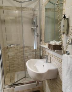 a bathroom with a sink and a glass shower at Hotel PRINCIPE AMEDEO in Rome +36 photos