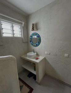 a bathroom with a sink and a mirror on the wall at Studio Leliya 2 in Malindi +18 photos