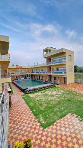 a large building with a swimming pool in front of it at Kheya Tori Resort in Tajpur