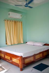a wooden bed in a room with a curtain at Kheya Tori Resort in Tajpur