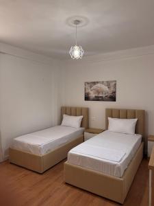 two beds in a room with white walls at Blendi Guest House in Golem