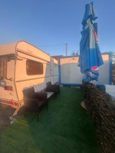an rv with a patio with an umbrella and chairs at A little paradise 2 in Radanovići