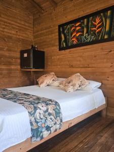 a bedroom with a bed in a wooden wall at La Chorrera ecohotel in Cocorná