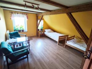 a living room with two beds and a table at Agroturystyka Pod Leszczyną in Wambierzyce
