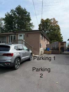 a car parked in a parking lot in front of a house at Ideal Bachelor Suite For Couples in Aurora in Aurora
