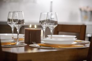 a table with wine glasses and plates and a candle at Volos Comfort Stay with free parking in Volos