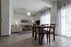 a living room with a table and chairs and a couch at Volos Comfort Stay with free parking in Volos