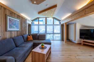 a living room with a couch and a tv at Alpenapart Singer - contactless check-in in Reutte