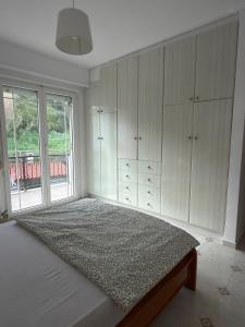 a bedroom with a bed and a large window at Meltemi Evia in Paralía +4 photos