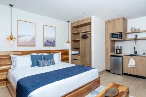 a bedroom with a large bed and a kitchen at Mono Luxe Villas in Tamarindo