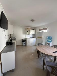 a kitchen with a table and a table and a kitchen with a tableablish at Casa Hostal , Mejillones in Mejillones +12 photos