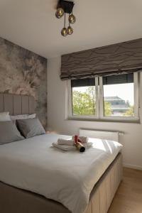 a bedroom with a large white bed with two windows at Luxury Opus Osijek - Self Check in, Free Private Parking in Osijek