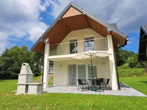 a house with a patio with a table and chairs at U Znajomych in Wołkowyja