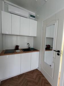 a kitchen with white cabinets and a sink at Pas Alksnius in Rotuliai