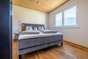 a bedroom with a large bed with a window at Alpenapart Singer - contactless check-in in Reutte