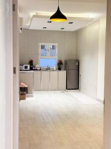 an empty room with a kitchen with a refrigerator at Lava & Luna chalets in Sohar