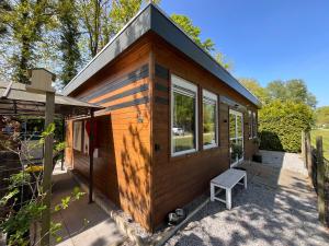a tiny house with a bench on a patio at La Vida in Lanaken