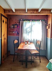 a table and chairs in a room with a window at Victoria Cabin in Victoria