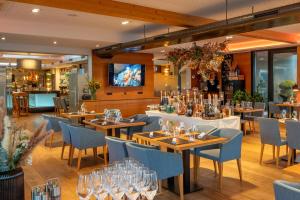 un ristorante con tavoli in legno e sedie blu di Patrix Hotel, Restaurant, Bar a Frankenburg
