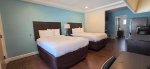 a hotel room with two beds and a table at Curtis Inn & Suites in Hollywood +10 photos