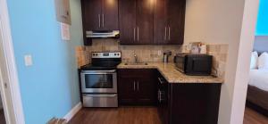 a small kitchen with a sink and a microwave at Curtis Inn & Suites in Hollywood