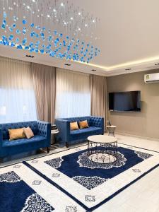 a living room with blue couches and a table at Lava & Luna chalets in Sohar