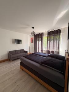 a bedroom with a large bed and a couch at City-Apartment Leimbach in Siegen