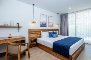 a bedroom with a bed and a desk and a chair at Mono Luxe Villas in Tamarindo