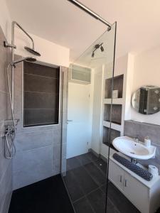 a bathroom with a glass shower and a sink at City-Apartment Leimbach in Siegen +26 photos